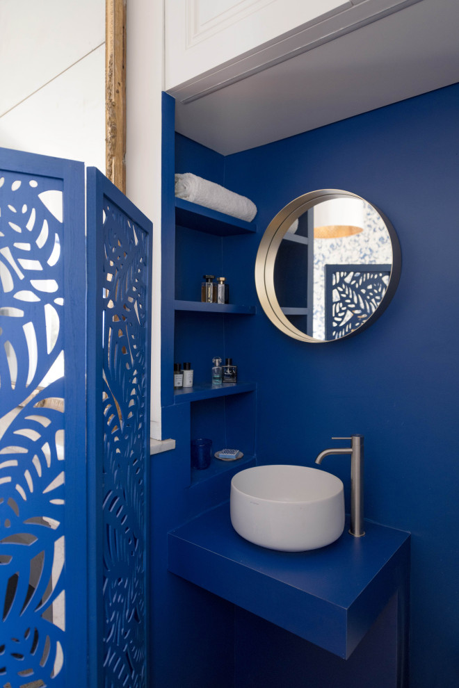 Foto de aseo clásico renovado pequeño con paredes azules, suelo de madera en tonos medios, lavabo sobreencimera y encimera de laminado