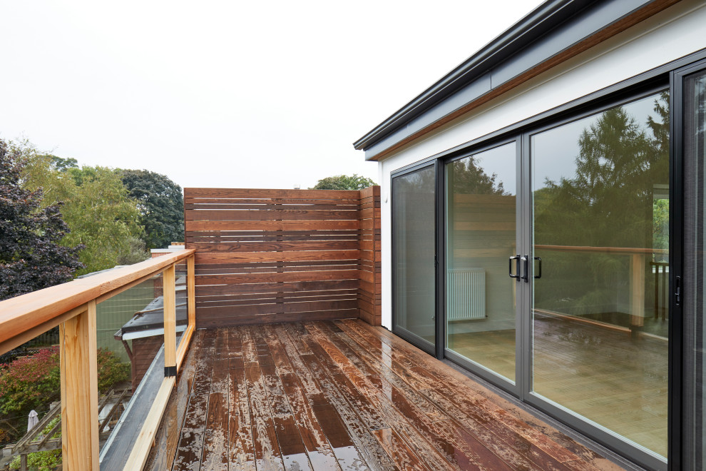 Ejemplo de balcones tradicional renovado de tamaño medio sin cubierta con privacidad y barandilla de madera