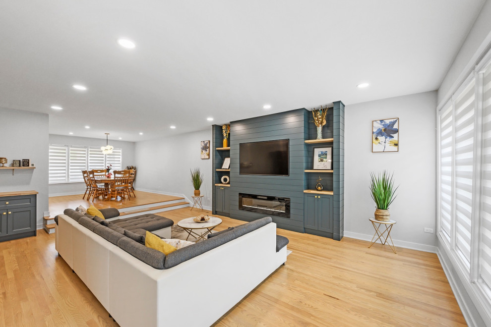 Idéer för stora funkis vardagsrum, med en hemmabar, blå väggar, ljust trägolv, en standard öppen spis och en inbyggd mediavägg