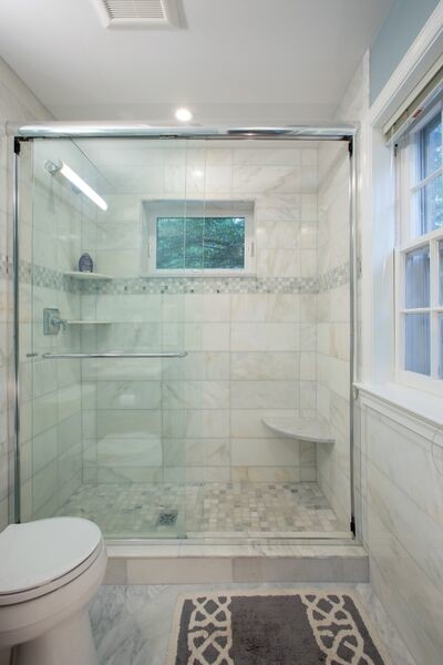 Photo of a small transitional master bathroom in DC Metro with an undermount sink, glass-front cabinets, dark wood cabinets, marble benchtops, an alcove tub, an alcove shower, a one-piece toilet, white tile, stone tile, white walls and marble floors.