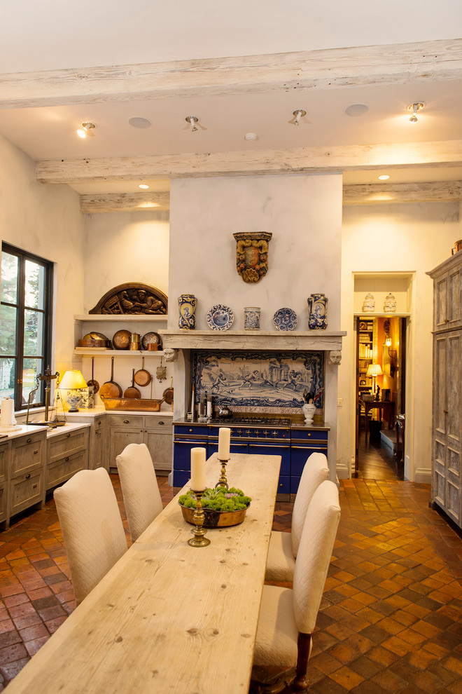 Inspiration for a large mediterranean separate kitchen in Nashville with recessed-panel cabinets, distressed cabinets, marble benchtops, white splashback, ceramic splashback, coloured appliances and terra-cotta floors.