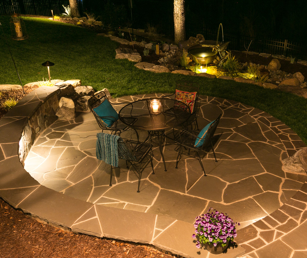 Inspiration for a large eclectic backyard patio in Charlotte with a water feature, natural stone pavers and no cover.