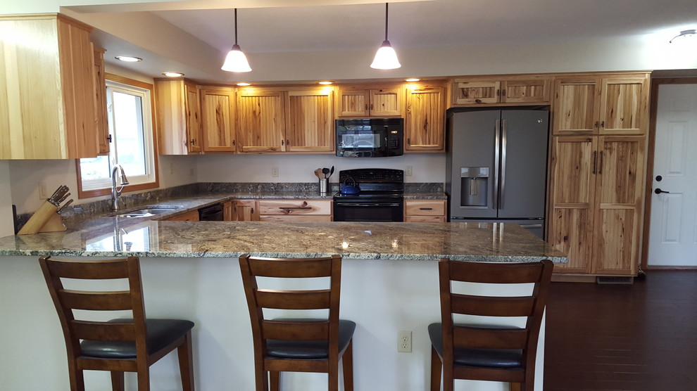 Inspiration for an u-shaped dark wood floor eat-in kitchen remodel with an undermount sink, stainless steel appliances and a peninsula