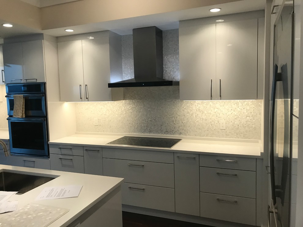 Inspiration for a large modern single-wall enclosed kitchen remodel with a double-bowl sink, marble backsplash and stainless steel appliances