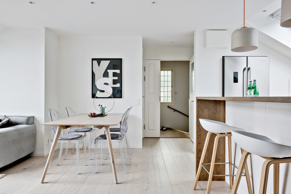 Inspiration for a mid-sized scandinavian dining room in Gothenburg with white walls, light hardwood floors and beige floor.