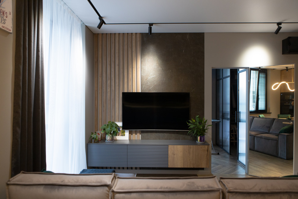 Kleines Modernes Wohnzimmer mit beiger Wandfarbe, braunem Holzboden, TV-Wand und beigem Boden in Sankt Petersburg