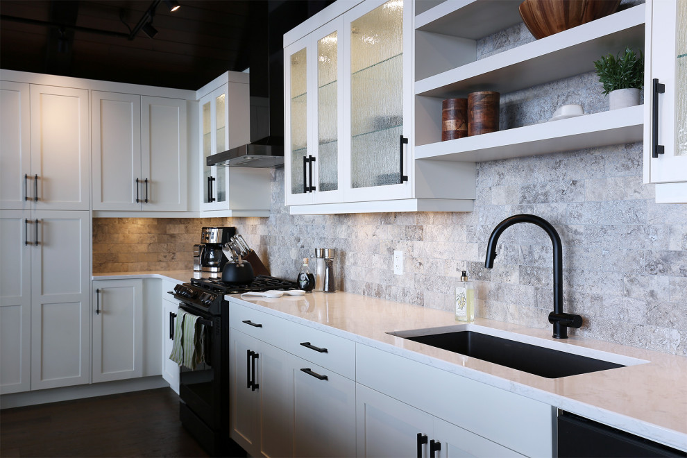 Rustik inredning av ett stort vit vitt kök, med en undermonterad diskho, skåp i shakerstil, vita skåp, bänkskiva i kvartsit, grått stänkskydd, stänkskydd i kalk, rostfria vitvaror, mellanmörkt trägolv, en köksö och brunt golv