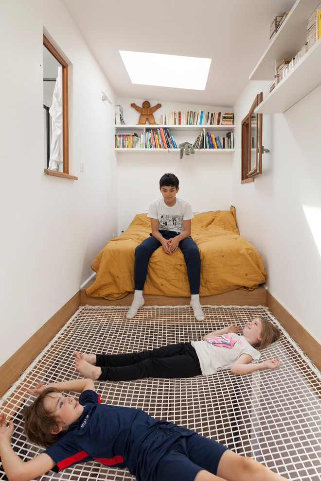 Contemporary gender-neutral kids' playroom in Paris with white walls for kids 4-10 years old.