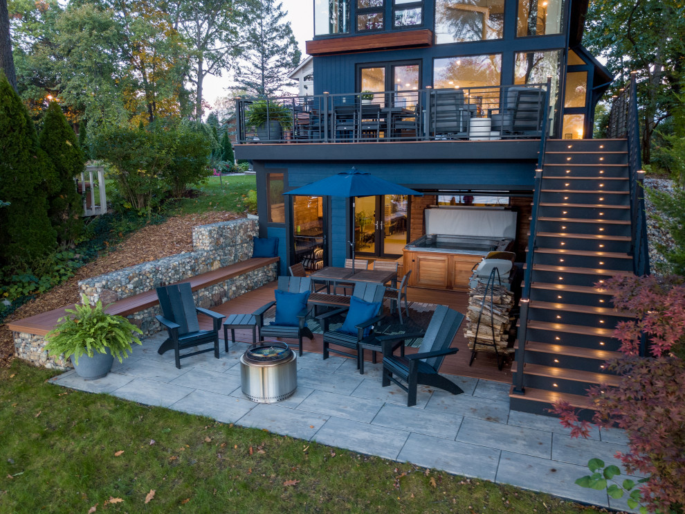 Esempio di un patio o portico minimalista di medie dimensioni e davanti casa con un focolare, pavimentazioni in cemento e un tetto a sbalzo