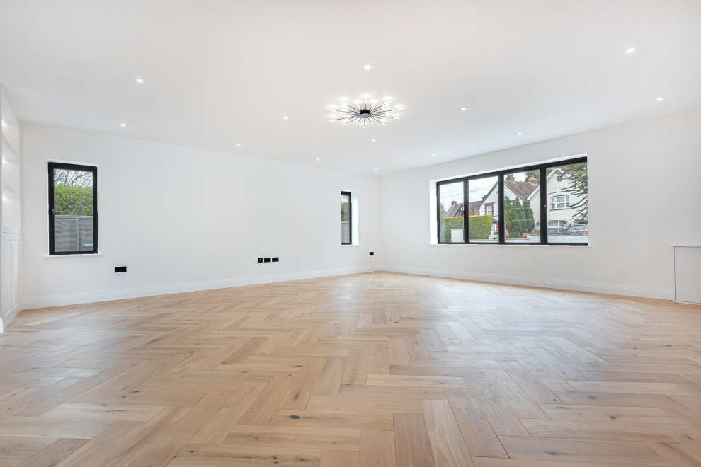 Photo of a large contemporary living room in Surrey with white walls and light hardwood floors.