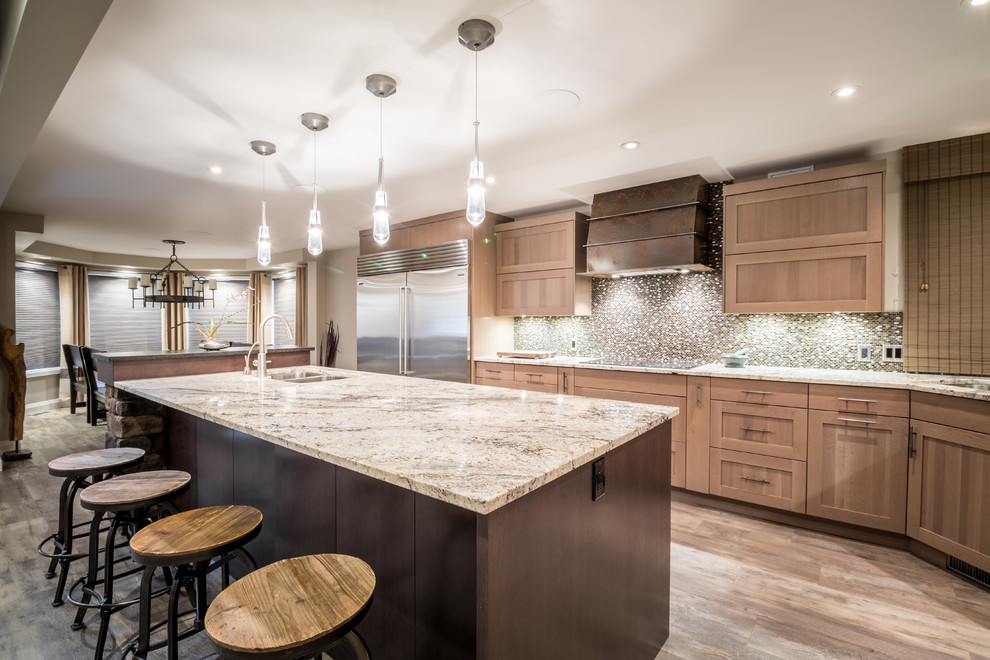 Example of a transitional l-shaped vinyl floor eat-in kitchen design with an undermount sink, shaker cabinets, light wood cabinets, granite countertops, brown backsplash, mosaic tile backsplash, stainless steel appliances and an island