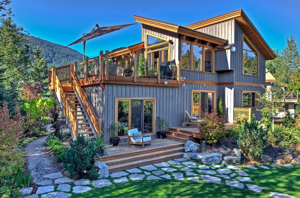 This is an example of a large country three-storey grey exterior in Vancouver with wood siding and a shed roof.