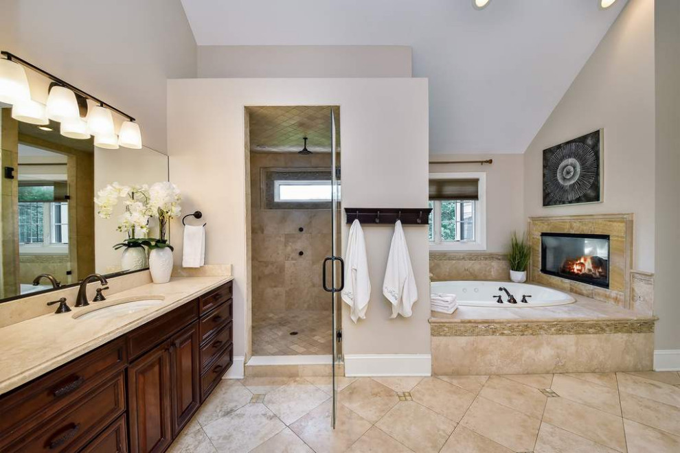 Drop-in bathtub - large transitional master beige tile and porcelain tile porcelain tile, double-sink, vaulted ceiling and beige floor drop-in bathtub idea in Chicago with recessed-panel cabinets, brown cabinets, beige walls, an undermount sink, quartzite countertops, a hinged shower door, beige countertops and a built-in vanity