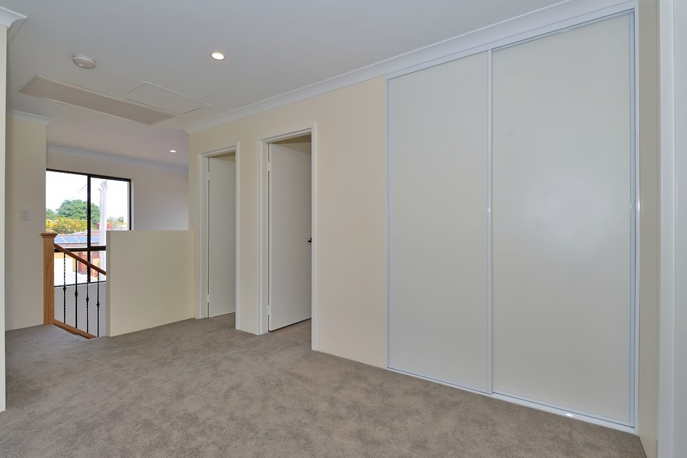 Photo of a mid-sized contemporary hallway in Perth with beige walls, carpet and grey floor.