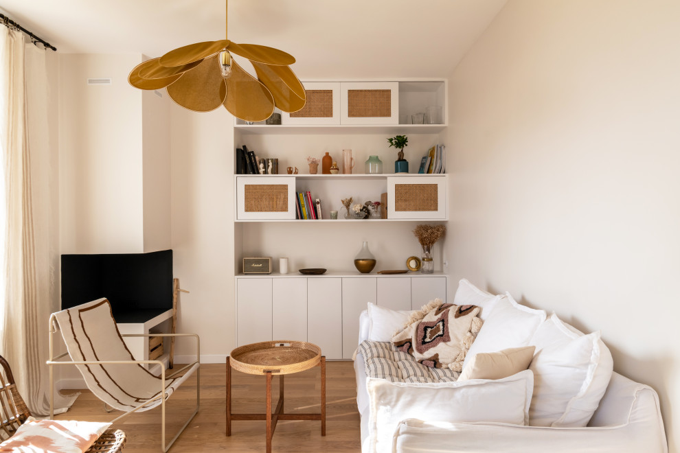 Inspiration for a small scandinavian open concept living room in Paris with a library, white walls, light hardwood floors, a corner fireplace, a plaster fireplace surround, a wall-mounted tv and brown floor.