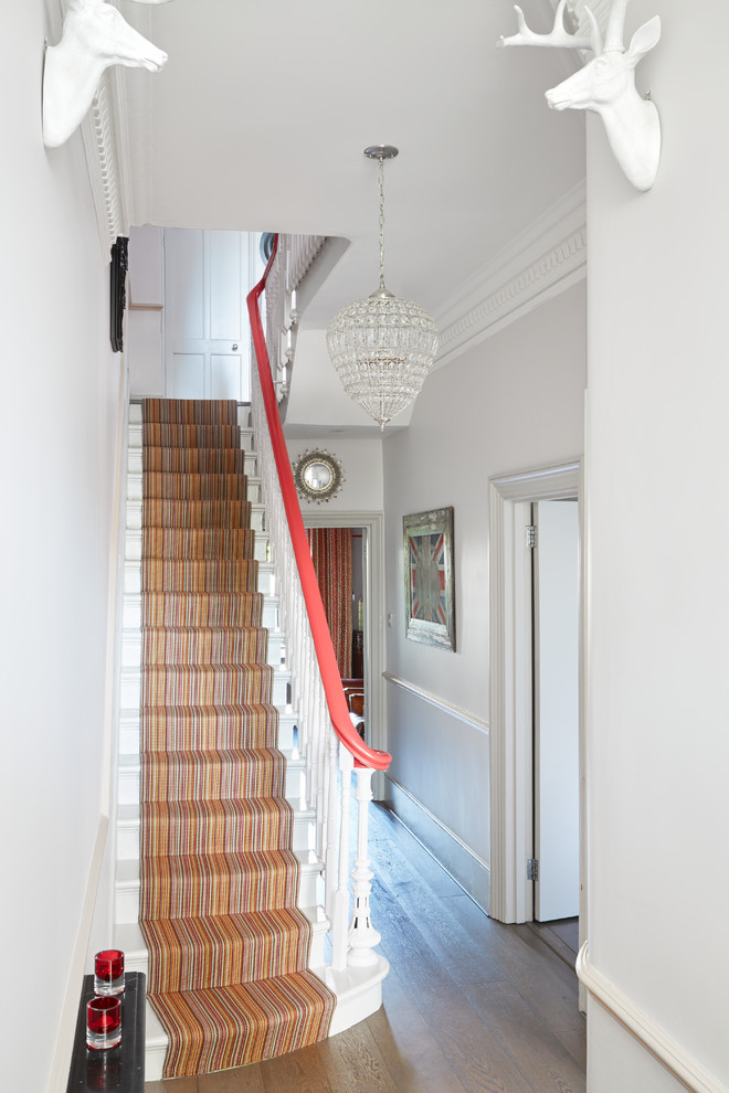 This is an example of a small eclectic carpeted straight staircase in London with carpet risers.