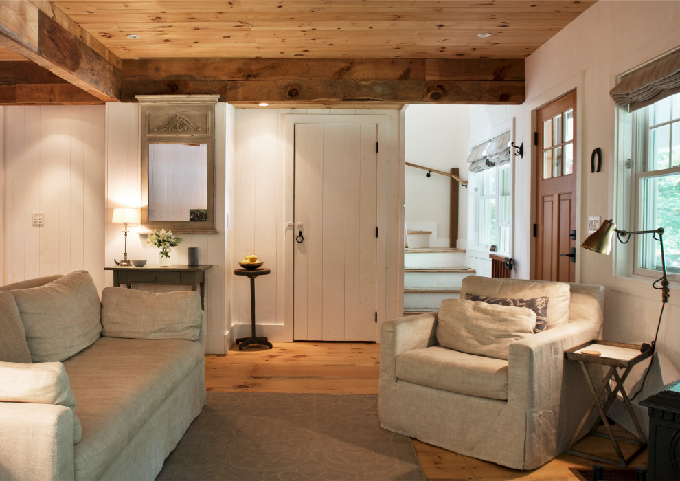 Cette photo montre un petit salon chic ouvert avec un mur blanc, parquet clair, un poêle à bois, un manteau de cheminée en carrelage, aucun téléviseur, un sol jaune, un plafond en bois et du lambris.