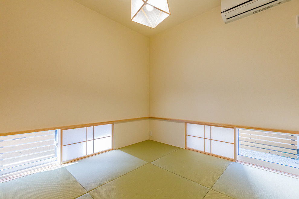 Ejemplo de habitación de invitados asiática de tamaño medio sin chimenea con paredes beige, tatami, suelo beige, papel pintado y papel pintado