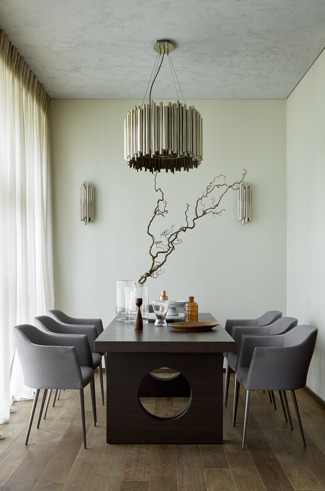 This is an example of a contemporary dining room in Moscow with white walls, dark hardwood floors and brown floor.