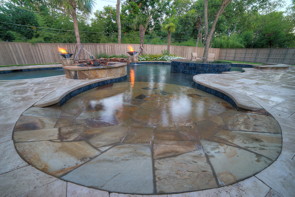 Photo of a large tropical backyard kidney-shaped pool in Dallas with a hot tub and tile.