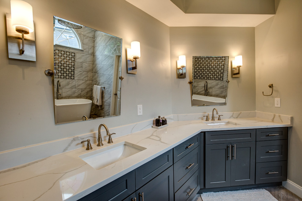 Design ideas for a large transitional master bathroom in Atlanta with shaker cabinets, blue cabinets, a freestanding tub, a corner shower, gray tile, porcelain tile, grey walls, an undermount sink, quartzite benchtops, a hinged shower door and white benchtops.