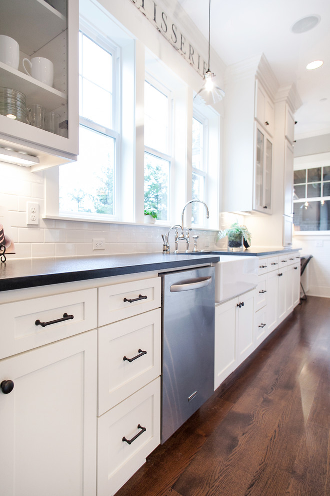 Inspiration for a transitional u-shaped eat-in kitchen remodel in Portland with a farmhouse sink, shaker cabinets, white cabinets, granite countertops, white backsplash, subway tile backsplash and stainless steel appliances