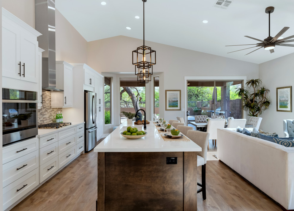 Example of a transitional vinyl floor and brown floor kitchen design in Phoenix with shaker cabinets, dark wood cabinets, quartz countertops, an island and white countertops
