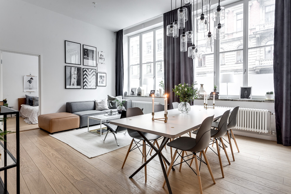 Design ideas for a large scandinavian open plan dining in Stockholm with white walls, light hardwood floors and no fireplace.