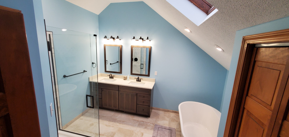 Large country master bathroom in Chicago with shaker cabinets, brown cabinets, a freestanding tub, a corner shower, white tile, ceramic tile, blue walls, porcelain floors, an undermount sink, quartzite benchtops, beige floor, a hinged shower door, beige benchtops, a double vanity, a built-in vanity and vaulted.