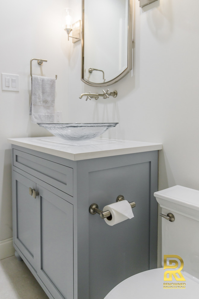 Cette image montre une petite salle de bain traditionnelle avec un placard à porte shaker, des portes de placard grises, WC à poser, un carrelage blanc, des carreaux de porcelaine, un mur blanc, un sol en carrelage de céramique, une vasque, un plan de toilette en quartz modifié, un sol blanc, une cabine de douche à porte battante, un plan de toilette blanc, un banc de douche et meuble-lavabo encastré.