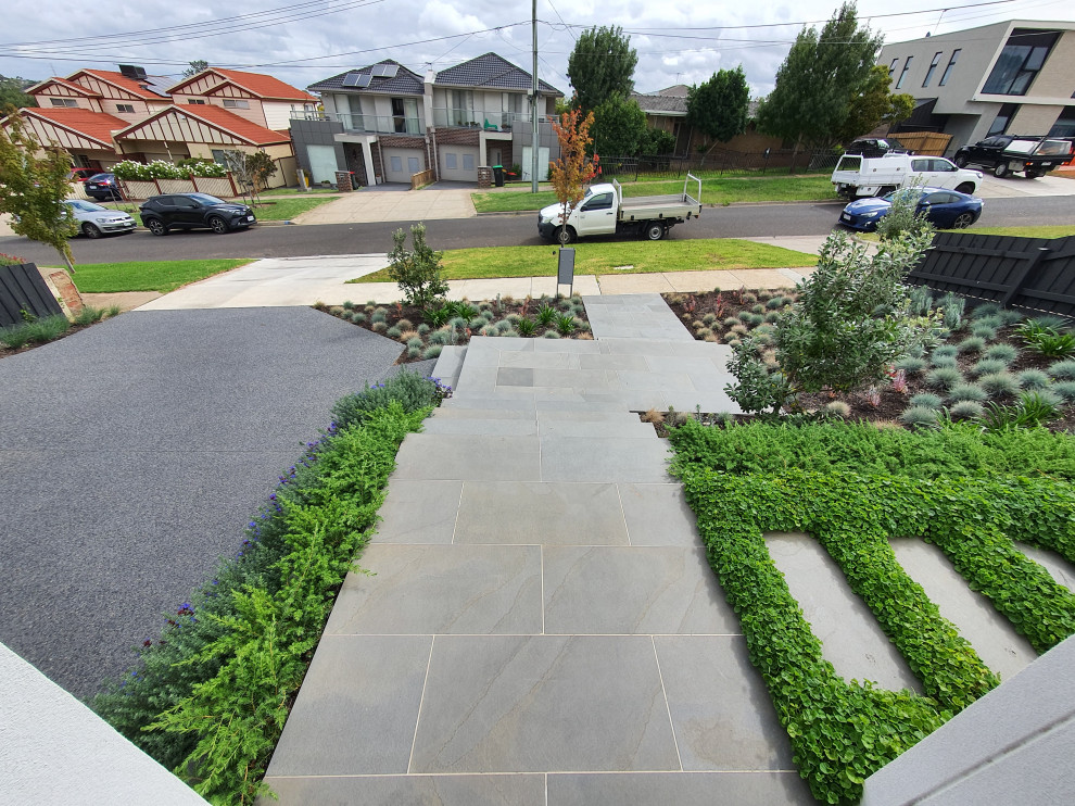 Inspiration for a large modern front yard full sun formal garden for spring in Melbourne with a garden path and natural stone pavers.
