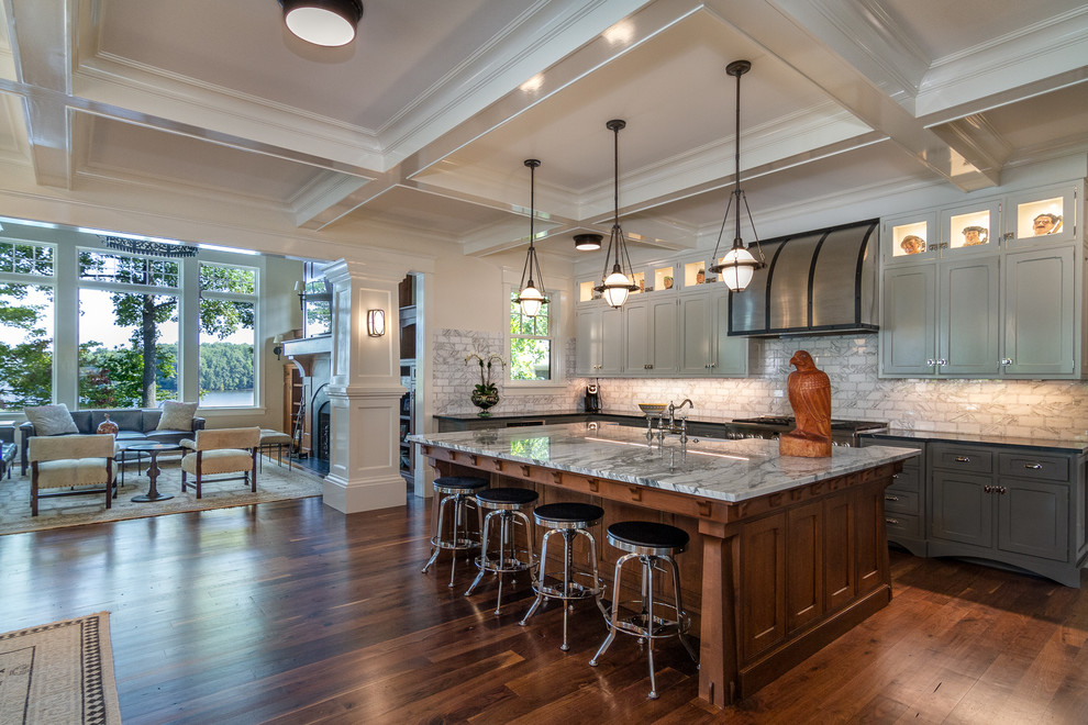 Inspiration for a traditional open plan kitchen in Charlotte with a farmhouse sink, shaker cabinets, grey cabinets, white splashback, subway tile splashback, stainless steel appliances, dark hardwood floors, with island, brown floor and grey benchtop.