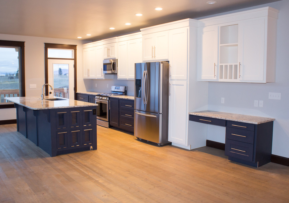 Example of a mid-sized transitional single-wall medium tone wood floor and brown floor eat-in kitchen design with an undermount sink, shaker cabinets, white cabinets, granite countertops, stainless steel appliances and an island