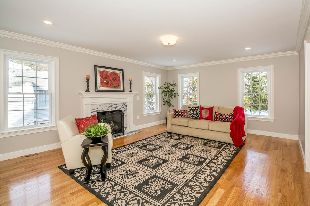Photo of a large traditional enclosed family room in Boston with grey walls, a standard fireplace, a stone fireplace surround, no tv, brown floor and medium hardwood floors.