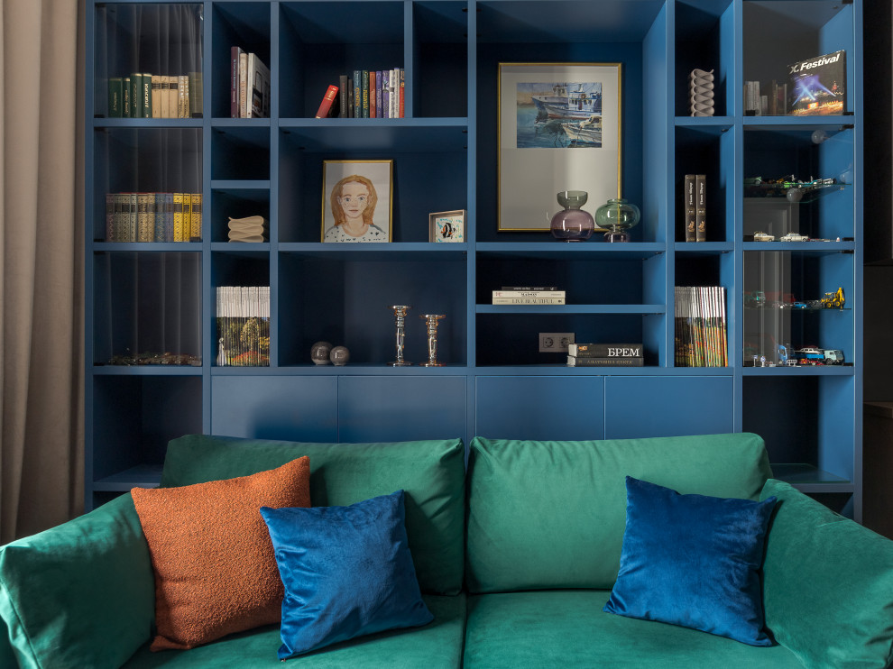 Foto de sala de estar con biblioteca cerrada contemporánea pequeña con paredes azules, suelo de madera en tonos medios, televisor colgado en la pared y suelo beige