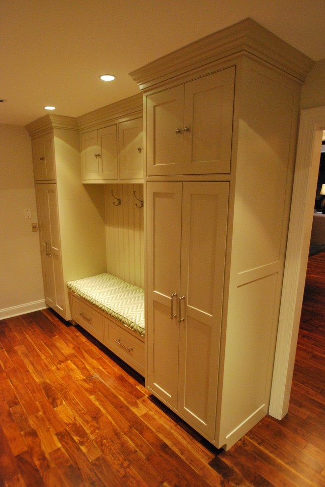 This is an example of a small traditional mudroom in DC Metro with beige walls, dark hardwood floors and brown floor.