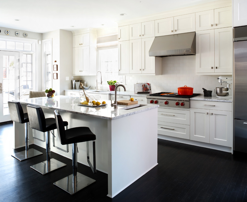 Example of a large transitional l-shaped dark wood floor eat-in kitchen design in DC Metro with shaker cabinets, white cabinets, stainless steel appliances, an island, an undermount sink, quartz countertops, white backsplash and subway tile backsplash