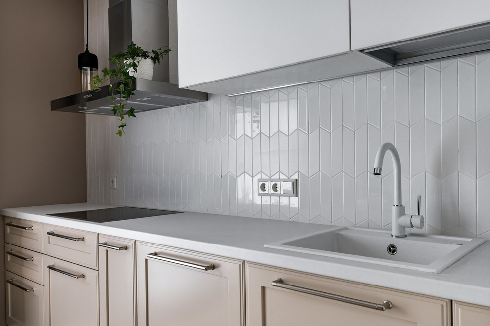 This is an example of a scandinavian l-shaped separate kitchen in Saint Petersburg with a drop-in sink, recessed-panel cabinets, beige cabinets, white splashback and white benchtop.