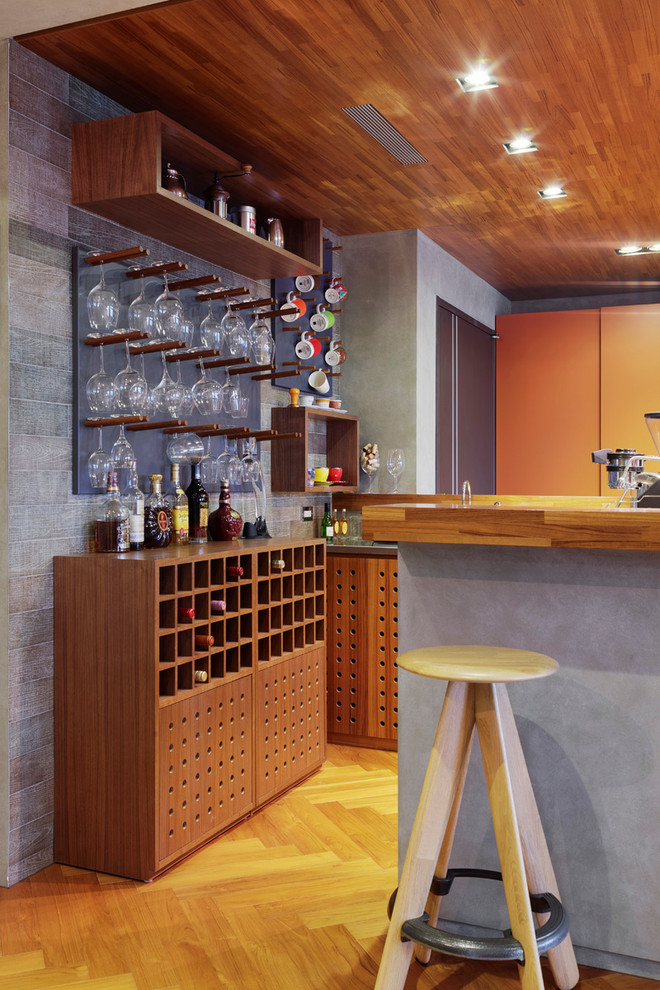 Contemporary seated home bar in New York with medium wood cabinets, wood benchtops and light hardwood floors.