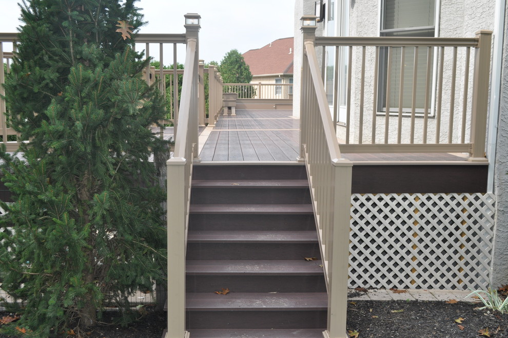 Example of a mid-sized transitional backyard deck design with no cover