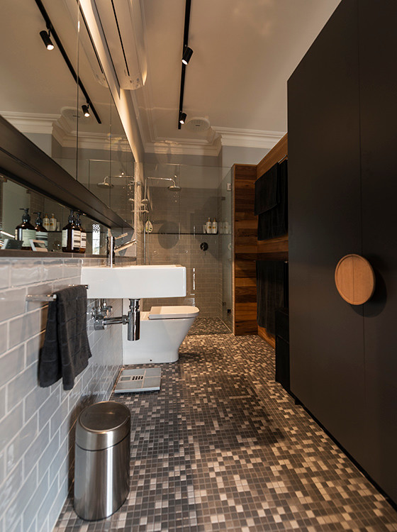 Photo of a large traditional master bathroom in Melbourne with flat-panel cabinets, black cabinets, an alcove shower, a two-piece toilet, gray tile, subway tile, grey walls, mosaic tile floors, a wall-mount sink, tile benchtops, grey floor and a hinged shower door.