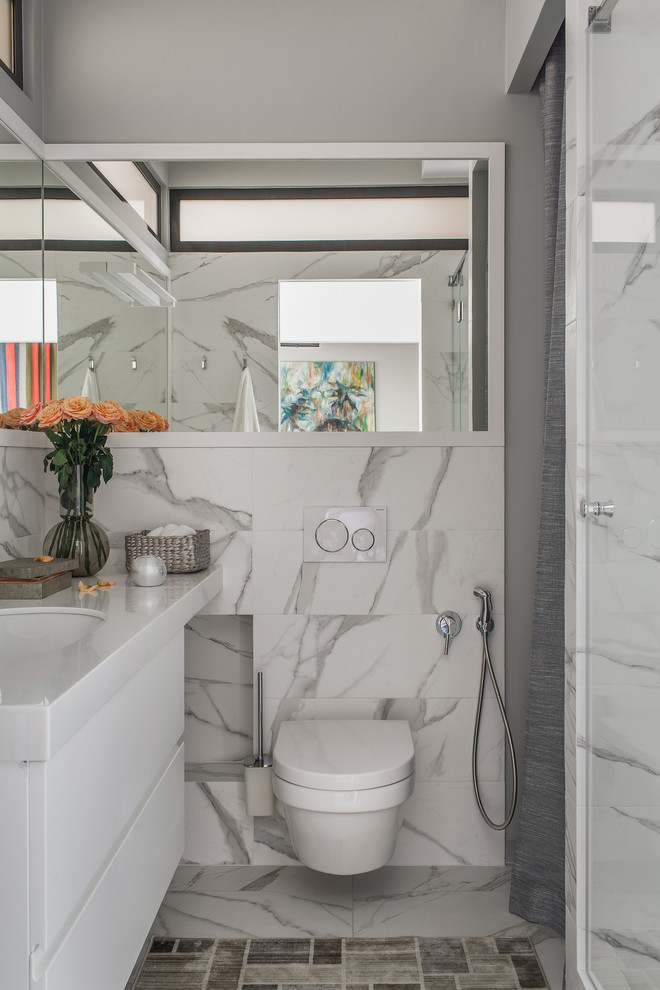 This is an example of a small scandinavian 3/4 bathroom in Other with flat-panel cabinets, white cabinets, a wall-mount toilet, white tile, gray tile, multi-coloured tile, grey walls, an undermount sink, white benchtops and multi-coloured floor.