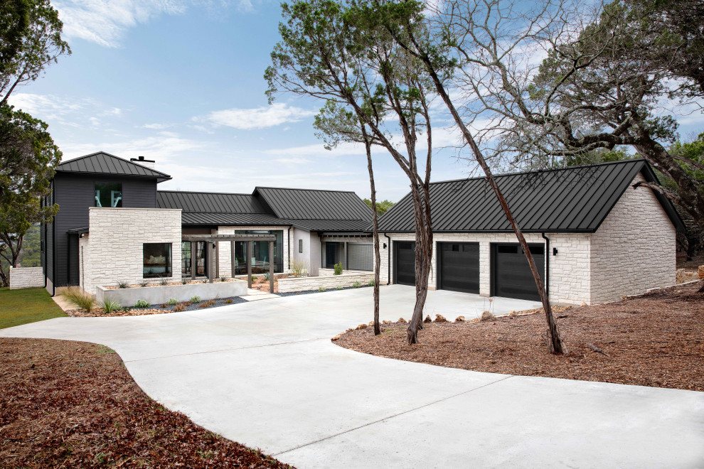 Inspiration pour une façade de maison à un étage avec un revêtement mixte, un toit en métal et un toit noir.