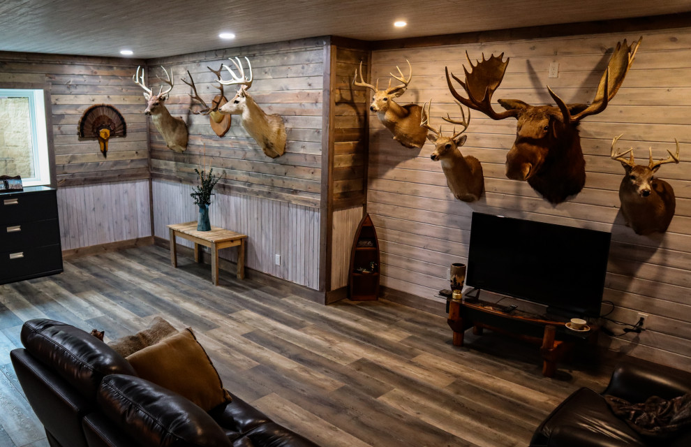 Photo of a mid-sized country look-out basement in Detroit with a game room, grey walls, vinyl floors, grey floor, timber and planked wall panelling.