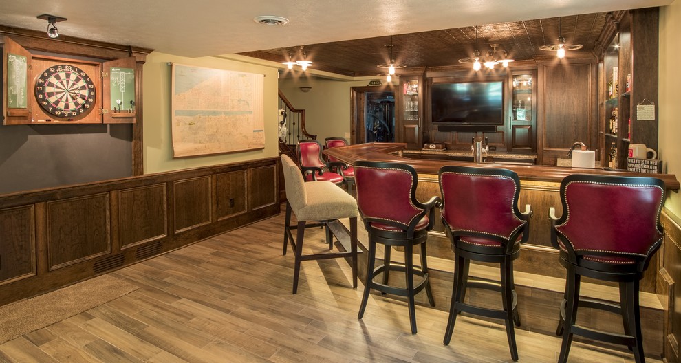 Inspiration for a large traditional u-shaped seated home bar in Other with an undermount sink, raised-panel cabinets, dark wood cabinets, quartz benchtops and porcelain floors.