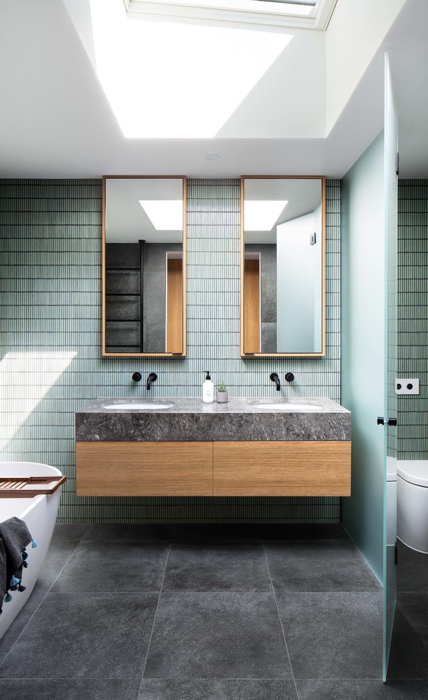 Mid-sized contemporary master bathroom in Melbourne with flat-panel cabinets, white cabinets, a drop-in tub, a corner shower, a two-piece toilet, black and white tile, gray tile, ceramic tile, grey walls, ceramic floors, a drop-in sink, engineered quartz benchtops, grey floor, a hinged shower door and white benchtops.