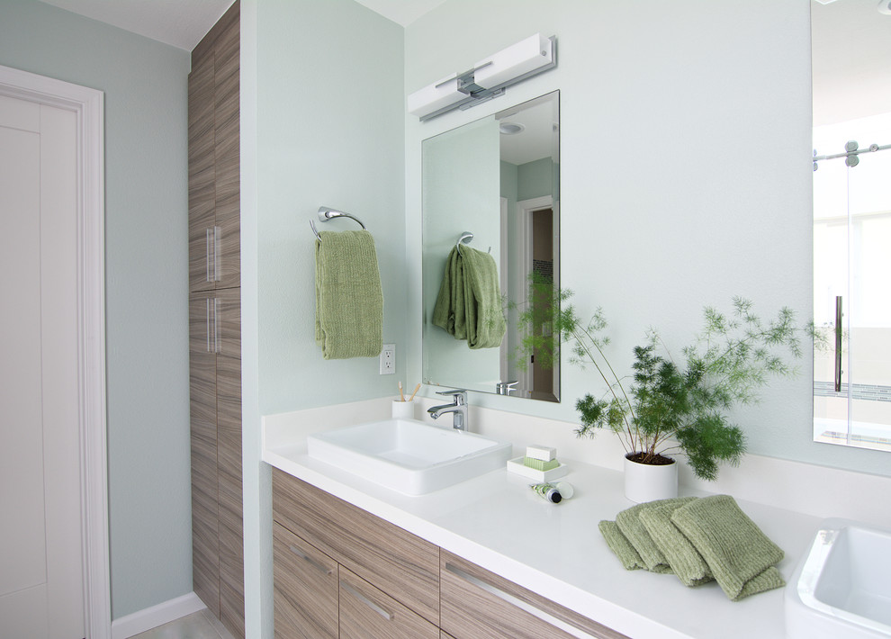 This is an example of a mid-sized modern master bathroom in Seattle with flat-panel cabinets, light wood cabinets, a drop-in tub, an open shower, a one-piece toilet, beige tile, porcelain tile, green walls, porcelain floors, a vessel sink and engineered quartz benchtops.