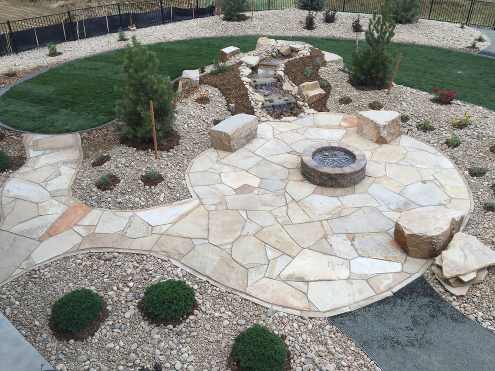 Design ideas for a mid-sized arts and crafts backyard full sun xeriscape in Denver with a water feature and natural stone pavers.