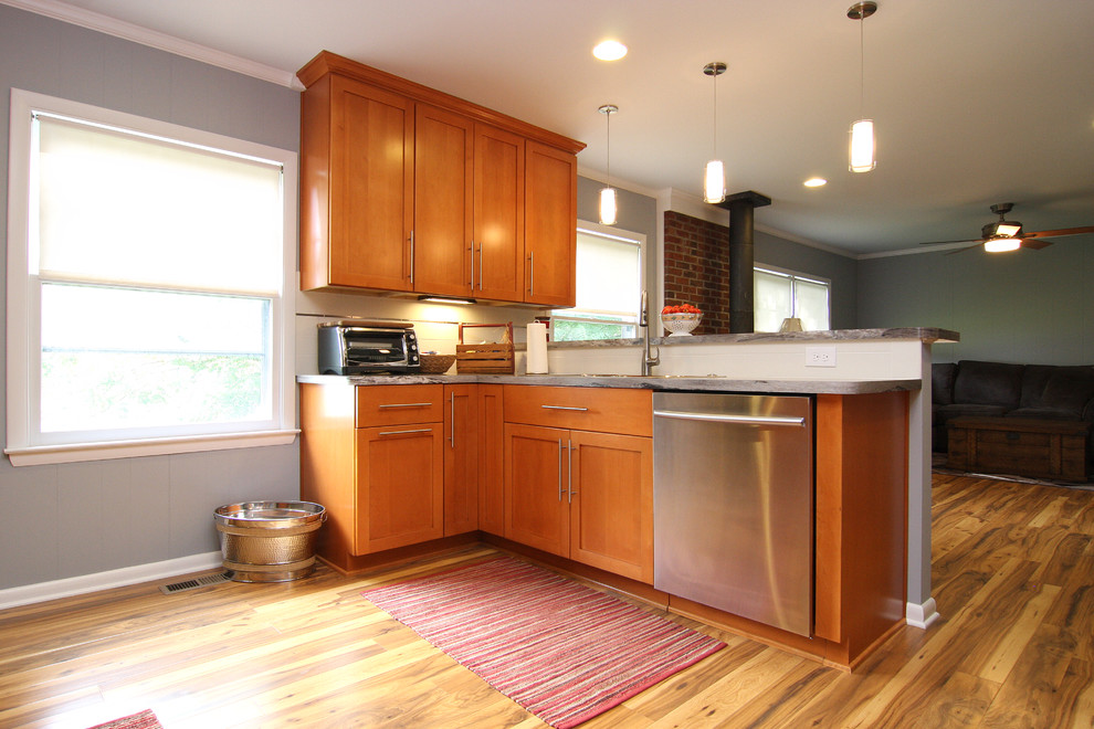 Large transitional u-shaped medium tone wood floor eat-in kitchen photo with a drop-in sink, recessed-panel cabinets, medium tone wood cabinets, laminate countertops, white backsplash, ceramic backsplash, stainless steel appliances and a peninsula