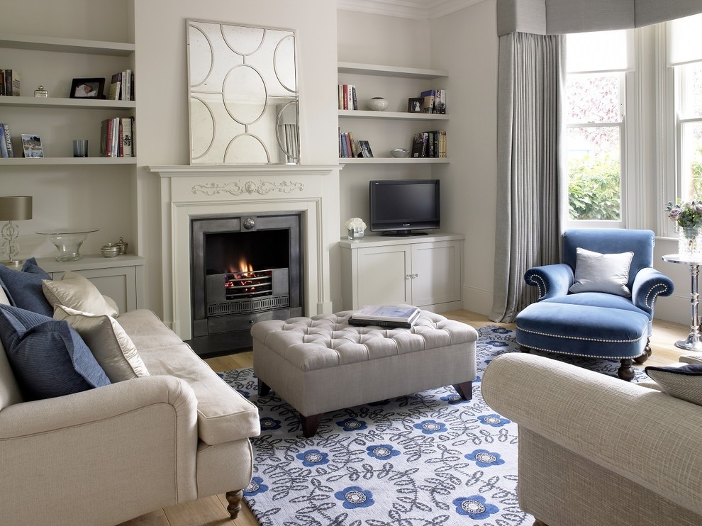 Inspiration for a small traditional enclosed family room in Surrey with grey walls, light hardwood floors, a standard fireplace, a stone fireplace surround, a freestanding tv and beige floor.